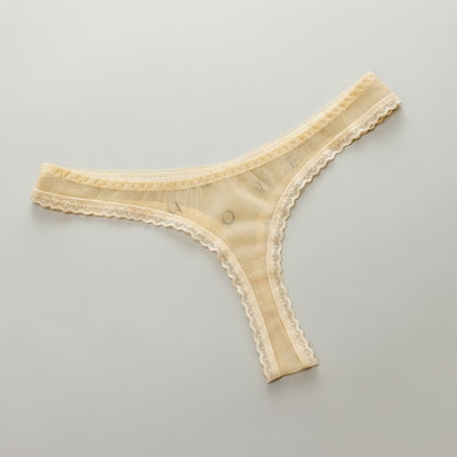 Beige lace thong on a white card with text on a gray background