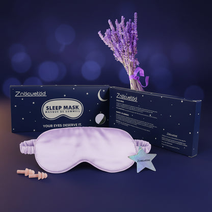 Purple sleep mask with packaging and lavender flowers on a white background